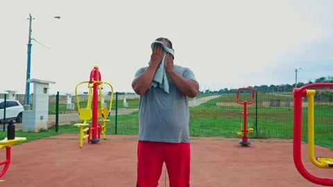 A man in a grey shirt stands in front of a row of exercise equipment Stock Footage 321753055