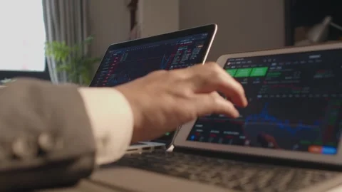 Man in Grey Suit Analyzing Financial Charts on Laptop Screen Vídeos de archivo 336552793