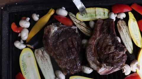 Man grilling and flipping steak and vegetables on the grill close-up Video stock 280471553