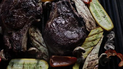 Man grilling and flipping steak and vegetables on the grill close-up Stock Footage 280472433