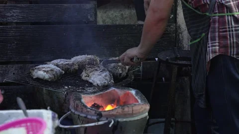 Man grilling and plating salted fish, Bangkok Street Food, charcoal grill. Stock Footage 221142700