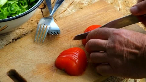 Man Grilling Meat and Cutting Fresh Tomatoes for Picnic in Sunny Garden Stock Footage 328361745