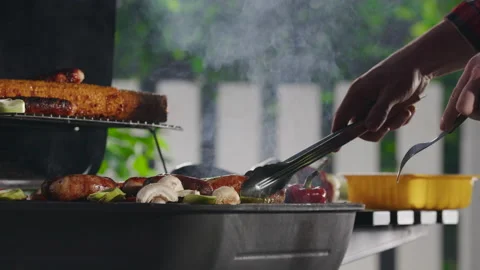 Man Grilling Meat Sausages on Fire Outdoors Stock Footage 211735906