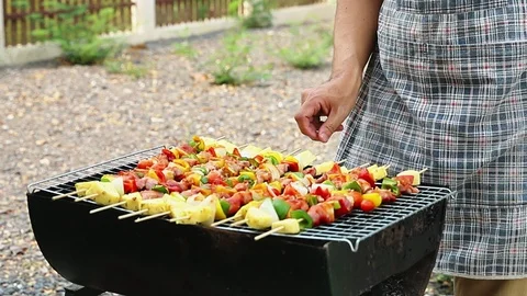 A man grilling pork and barbecue in dinner party. Stock Footage 126344053