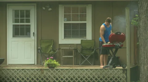 Man Grilling in the Rain 2 Stock Footage 52181440