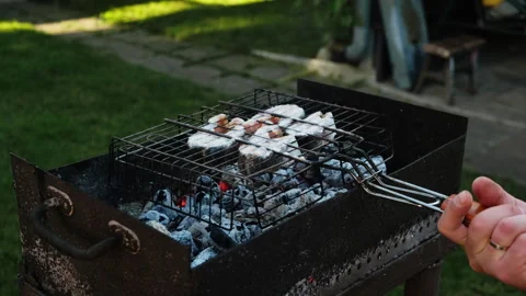 Man grilling steaks of salmon fish in backyard during summer weekend Stock Footage 340332984