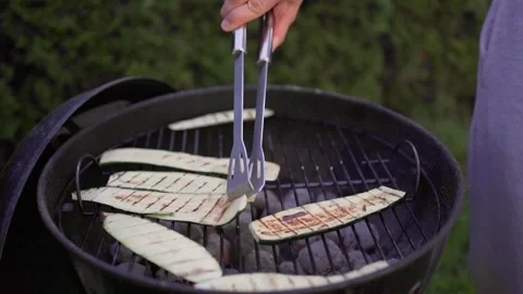 Man grilling vegetable on grill during family summer garden party, close-up Stock Footage 246661154