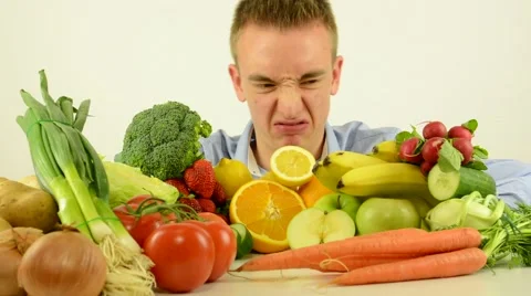 Man grimaces (distaste) - healthy food - vegetables and fruits- white background Stock Footage