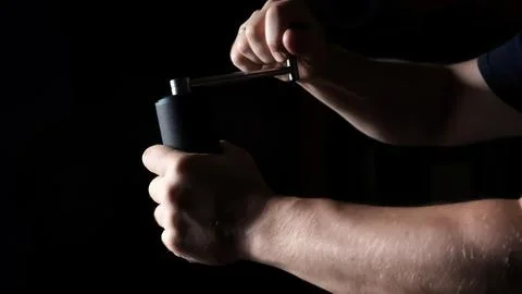 A man grinding beans using a hand coffee grinder. Milling handle process close Stock Photos