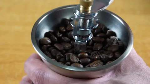Man grinding coffee beans using a manual hand coffee grinder Stock Footage 197740376