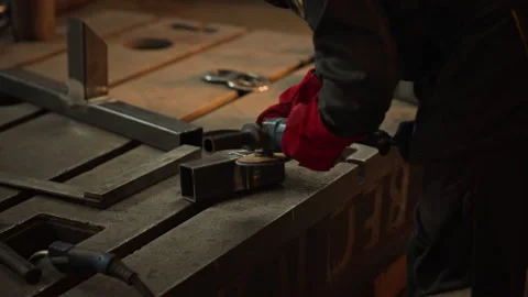Man Grinding Metal with Angle Grinder in Industrial Workshop Stock Footage 342498633