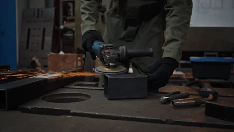 Man Grinding Metal Component with Angle Grinder in Workshop Stock Footage 342502278