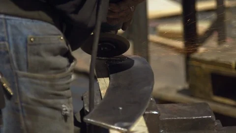Man grinding metal using electric disc with orange sparks in workshop Stock Footage 90268155