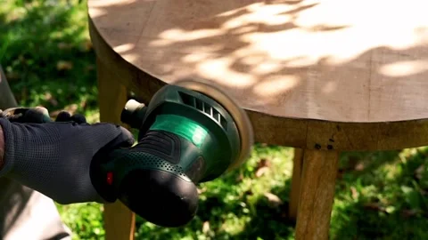 Man grinding old table in the garden,  focus on hands 120fps Stock Footage 126774148