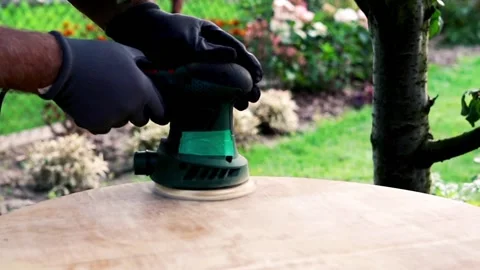 Man grinding old table in the garden,  focus on hands 120fps Video stock 126774316