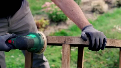 Man grinding old table in the garden,  focus on hands 120fps Stock Footage 126774548