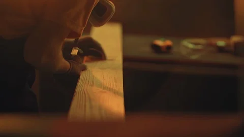 Man grinding plank with sandpaper in workshop during the sunset. Woodworking Stock Footage 114695650