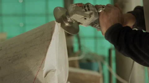 Man grinding stone with a power tool in a workshop Stock Footage 274994730