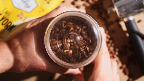 Man grinds coffee beans into a coffee grinder, early morning coffee 動画素材 120188302