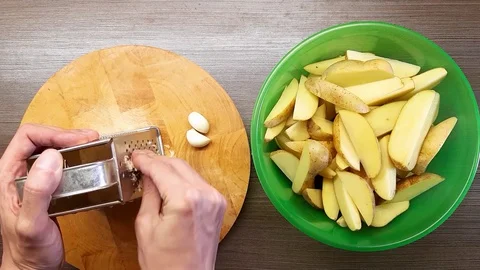 A man grinds garlic on a kitchen grater. The view from the top. Stock Footage 128839074