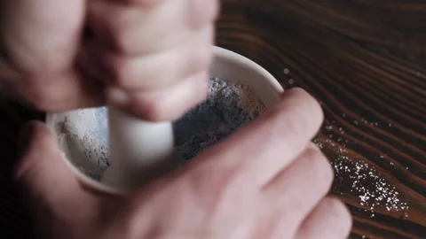 Man grinds lime with blue paint pigment in a mortar. grinding the ingredient  Stock Footage 166557832