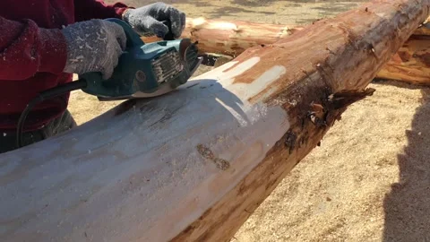 A man grinds a log from the bark with a grinding machine. Stock-Footage 156625078