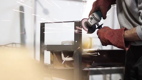 Man grinds metal structure with spinning disc tool Stock Footage 81858584