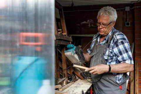 Man grinds the wood of angular grinding machine. Home carpentry workshop Stock Photos