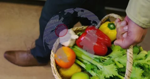 Man gripping basket in tech kitchen, lifting produce for delivery while globe Stock Footage 329124191