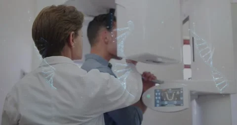 Man gripping handles causing tech aligning chin and unit arm preparing dental Stock Footage 330894520