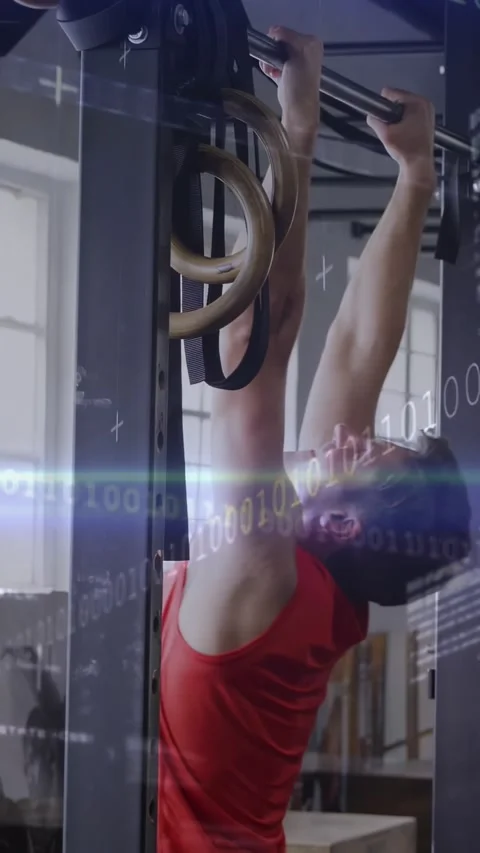 Man gripping pull-up bar and doing pull-ups in gym, building strength while Stock Footage 331050192