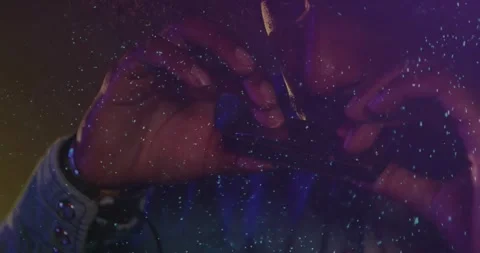 Man gripping rolled item, bringing to lips to place in film closeup, speckled Stock Footage 334316178