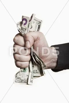 A man gripping a wad of US paper currency, close-up of hand Stock Photos
