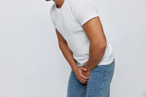 Man groin pain problems with potency and urination, urolithiasis, in white t Stock Photos