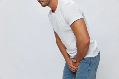 Man groin pain problems with potency and urination, urolithiasis, in white t Stock Photos