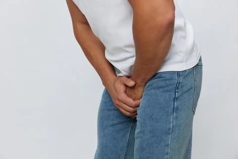 Man groin pain problems with potency and urination, urolithiasis, in white t Stock Photos
