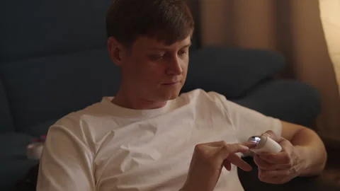 Man grooming fingernails at home with automatic nail clipper for personal Video stock 321401138