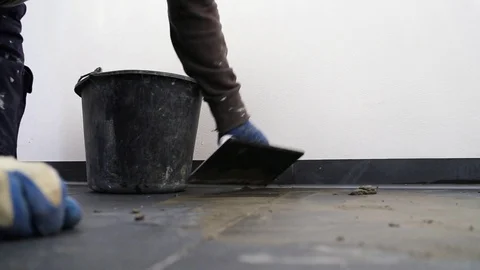 Man grouting the joints between the tiles with a sponge Stock Footage 127620552