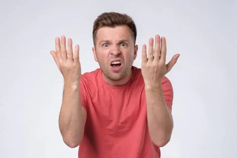 Man with grumpy grimace on his face,with mouth opened in shout, ready to argu 스톡 사진