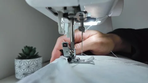 Man guiding fabric under sewing machine needle during stitching Video stock 333306906