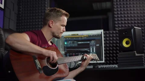 Man with guitar composing song in studio Stock Footage 142401329