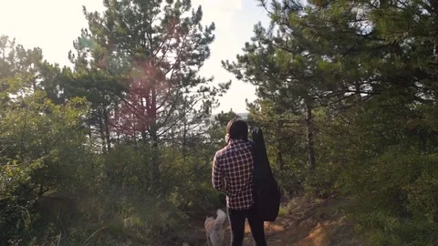 Man with guitar playing with two siberian husky dogs in forest Vidéo 84378073