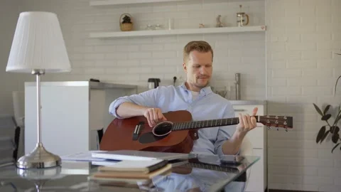 Man with guitar relaxing after work Stock Footage 133953670