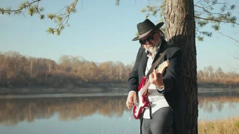 A man with a guitar on the shore Stock Footage 163242827