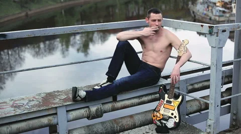 The man with the guitar smokes Stock Footage 50296326