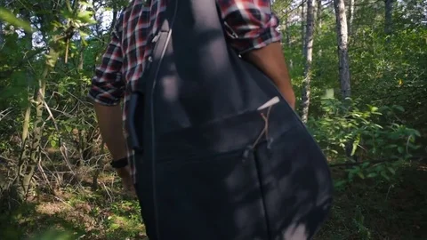 Man with guitar walking in forest Vidéo 84380075