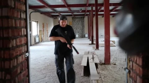 Man with gun in his hand and sensor going out of room to stairs Stock Footage 63659589