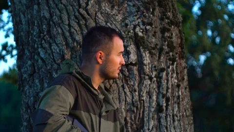 Man with a gun on the hunt behind a tree slow 動画素材 80321575