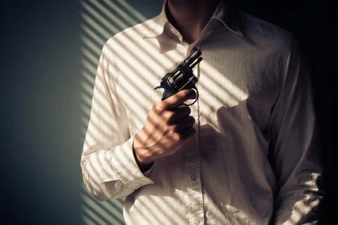 Man with gun by window Photos