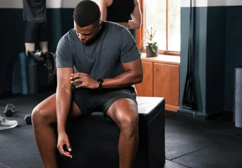 A man on a gym bench checking his watch, focusing on joint and leg workouts Stock Illustration